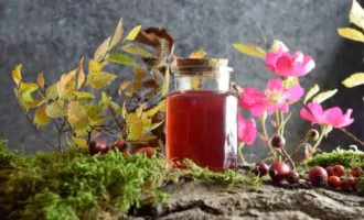 банка с сиропом шиповника и цветки шиповника